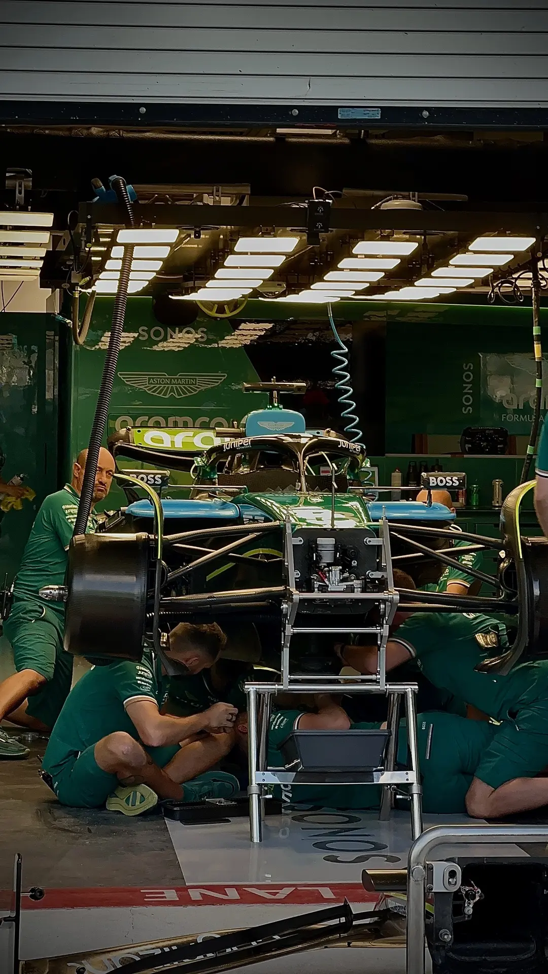Aston Martin Formula 1 pit-lane mechanics working on the car.