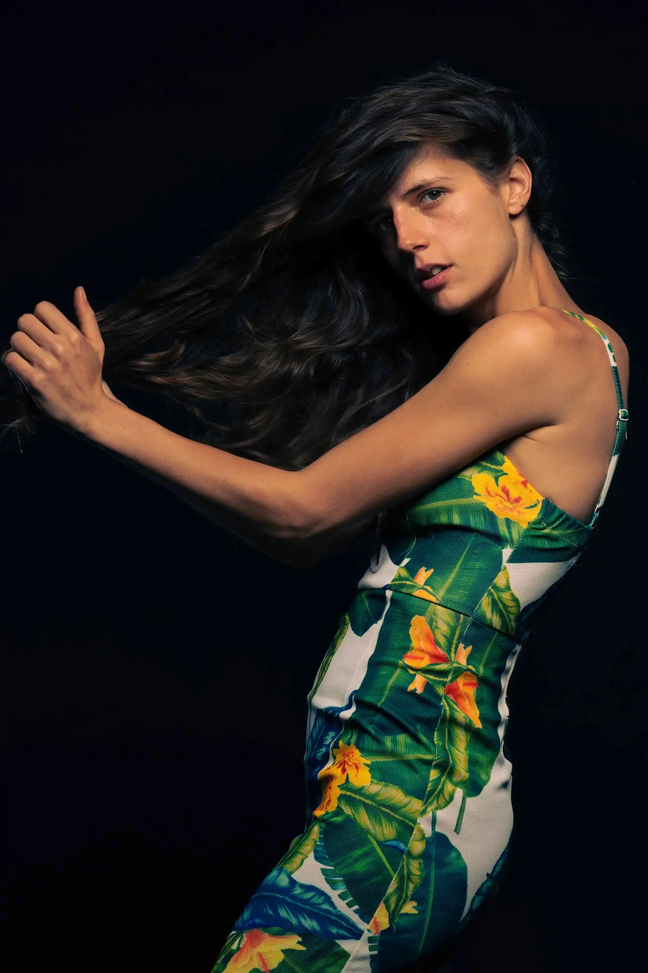 Studio portrait — floral dress, high-contrast lighting.